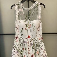 This Beautiful Dress Is A Junior Size 9 Great For Many Occasions Wether It Be Casual Or Formal ! It’s Like Brand New Warn Once For A Few Hours , Perfect Condition Back Zipper And Double Lace Layer Underneath. White Embroidered A-line Dress For Spring, Embroidered A-line Mini Dress For Spring, Feminine Summer Dress With Intricate Embroidery, Spring Sleeveless Dress With Embroidered Hem, Sleeveless Floral Embroidery Mini Dress For Spring, Sleeveless Mini Dress With Floral Embroidery For Spring, Spring Sleeveless Mini Dress With Floral Embroidery, Spring Embroidered Dress For Garden Party, Embroidered Mini Dress For Summer Garden Party