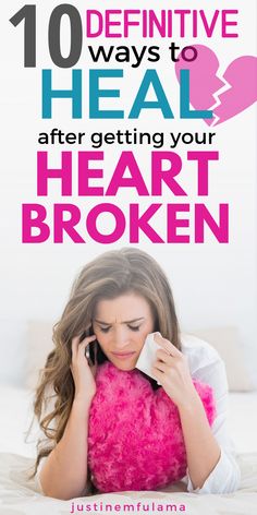 a woman laying in bed talking on her cell phone while holding a pink heart pillow