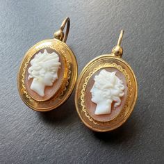 For best prices and offers, please visit our website at https://curiouslytimeless.com/ For sale a very refined pair of cameo earrings that transport you back to the elegance of the early 19th century. These earrings feature two portraits of a man/woman in antique style, which are crafted on shell and on two layers and circled by gold frames with wave motifs. As you wear these earrings, it appears as though the two people is looking at each other. The cameos are mounted in 18K yellow gold and the Gold Oval Cameo Earrings, Gold Cameo Drop Earrings, Victorian Cameo Yellow Gold Earrings, Gold-plated Shell-shaped Earrings, Gold Shell-shaped Shell Earrings, Types Of Shells, Sleeper Earrings, Cameo Earrings, Cameo Jewelry