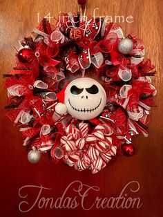 a red and white wreath with a skeleton on it