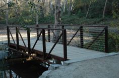 a wooden bridge over a small stream in the woods