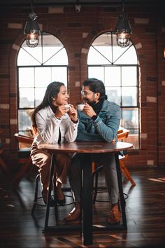 two people sitting at a table drinking coffee