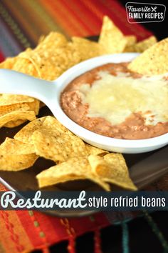 a plate with tortilla chips and a bowl of refried beans on it