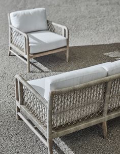 two white wicker chairs sitting on top of a carpeted floor next to each other