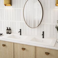 a bathroom with two sinks and a round mirror on the wall above them is decorated in white wood paneling