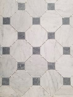 a white marble tile with black and grey squares