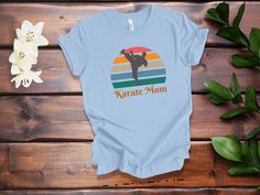 "Show your support for the amazing Karate Moms in your life with this special t-shirt! Perfect for a birthday, holiday, or just because, this fashionable and comfortable t-shirt is a great way to show your appreciation. It features a stylish design with a bold print that reads \"Karate Mom\" - a message of love and admiration for the hardworking moms supporting their athletes. It's also made of a soft and lightweight fabric, making it perfect for any occasion. Whether you're shopping for a speci Blue Screen Print T-shirt As Gift, Fun Blue T-shirt For Gifts, Blue T-shirt For Mother's Day Gift, Fun Blue T-shirt For Gift, Blue T-shirt With Text Print As A Gift, Blue Letter Print T-shirt As A Gift, Fun T-shirt For Mother's Day Gift, Mother's Day Gift Fun T-shirt, Fun Mother's Day Gift T-shirt