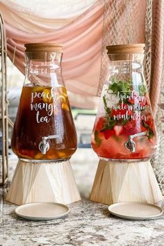 two glass jars filled with liquid sitting on top of a table