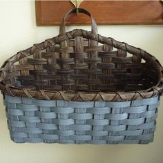 a woven basket hanging from a hook on a wall