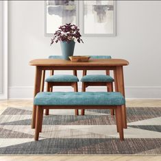 a wooden table with two blue chairs and a potted plant