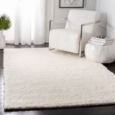 a living room with white furniture and rugs