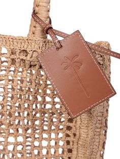 Two top handles Open top Main compartment Rectangle shape Woven raffia design Branded tag to the front Color: beige Depth: 9cm Height: 32cm Widht: 30cm 100% Raffia Composition: 100% Raffia