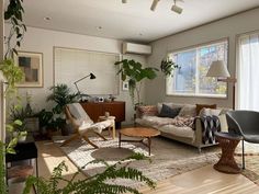 a living room filled with furniture and plants