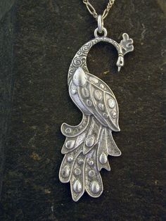 "This Peacock Bird pendant is Sterling Silver. The included chain is a Sterling Silver Figaro 50 chain. You may choose 16, 18 or 20 inch at the same price. Other length available at sightly higher prices. This Peacock Bird pendant measures 2 3/8\" tall by 7/8\" across. I hand cast all my pieces using the lost wax casting method. Please ask your needs. You may call me with questions, often I am out so please use my machine. 831-476-3176. Satisfaction Guaranteed! I send items USPS First Class unle Sterling Silver Necklace With Peacock Design, Silver Metal Necklace With Peacock Design, Silver Peacock Pendant Necklace, Elegant Silver Necklace With Peacock Design, Elegant Peacock Pendant Necklace, Elegant Peacock Color Pendant Necklace, Vintage Silver Jewelry With Peacock Design, Ornate Peacock Design Necklace For Gift, Peacock Bird