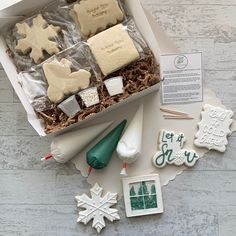 a box filled with cookies and icing on top of a wooden table next to other items