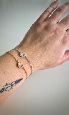 The perfect dainty celestial inspired bracelet for everyday styling. Let someone know how special they are with this pretty moon bracelet! The moon is said to symbolize, femininity, immortality, and eternity.   materials used: silver or gold stainless steel chain - adjustable 6-8 inches 16k white or yellow gold plated crescent moon charm with cubic zirconia - 10mm wide silver or gold stainless steel lobster clasp and extender As always, all parts are nickel free. C A R E ∙ T I P S To maintain the quality of your new Pink Raven jewelry, please: - Do not wear it to the pool, spa, or the beach  - Remove when sleeping, exercising, or doing other physically strenuous activities - Avoid contact with perfumes, body oils, and other chemicals, including household cleaners. - Do not use chemical jew Moon Minimalist, Pretty Moon, Raven Jewelry, Moon Bracelet, Sweet Necklace, Body Oils, Gold Moon, Zodiac Necklaces, Moon Jewelry