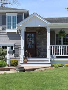 a gray house with white trim on the front porch