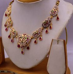 Stone Gold Necklace Indian, Gold Ruby Necklace With Intricate Design, Traditional Gold Ruby Necklaces, Bollywood Style Hand Set Yellow Gold Temple Necklace, Bollywood Style 22k Yellow Gold Kundan Necklace, 22k Yellow Gold Bollywood Kundan Necklace, Gold Temple Necklace With Intricate Ruby Design, Gold Ruby Temple Necklace As Gift, Festive Gold Plated Kundan Necklace