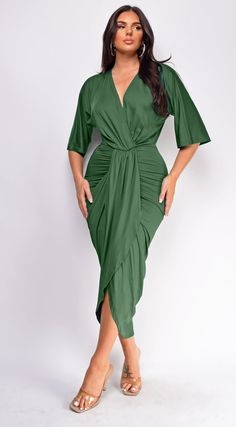 a woman wearing a green wrap dress