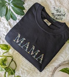 Mama Floral Tee This Mama t-shirt features a beautiful floral design that adds a touch of femininity to this cozy tee. The Comfort Colors tee is not only comfortable but also durable. It is perfect for both casual outings and lounging around the house.  Welcome to The Threaded Daisy store. Thank you for visiting!  Production & Shipping: Everything is embroidered to order just for you. On average your items will be shipped out within 3-5 days of ordering. The estimated shipping time in the US is 5-7 business days. Washing Instructions: Wash inside out, in cold water, on gentle cycle.  Tumble dry on low or let air dry. Feedback: If you have any issues with your order please reach out to us directly! We would love to resolve the issue and make sure you are happy with your new embroidered appa Black Cotton Tops With Machine Embroidery, Mother's Day Cotton T-shirt With Embroidered Graphics, Casual Tops With Multicolor Floral Embroidery, Casual Tops With Multicolor Floral Applique, Cotton Tops With Machine Embroidery And Relaxed Fit, Relaxed Fit Cotton Top With Machine Embroidery, Spring T-shirt With Multicolor Embroidered Text, Mother's Day Embroidered Text Crew Neck Top, Mother's Day Crew Neck Top With Embroidered Text