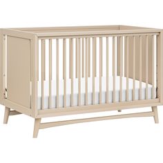 a baby crib with white sheets on the bottom and sides, in front of a white background