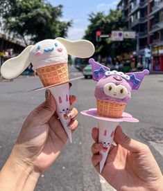 two people holding ice cream cones in their hands