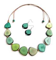 Green Tagua Necklace Set Necklace Length: 34 inches adjustable to shorter length Earrings Length: 1.17 inches About Tagua This Product is handcrafted from a palm tree nut native to the lush tropical rainforests of Ecuador. Also referred to as the Ecuadorean Ivory Palm, the Tagua tree produces several bushels of seed pods a year with up to 100 Tagua nuts per pod. These nuts are then harvested, dried, and crafted into a wide range of products from vibrant modern jewelry, ornate figurines, to every Unique Green Fair Trade Jewelry, Unique Green Fair Trade Necklace, Green Fair Trade Necklace For Gift, Organic Necklace, Eco Friendly Necklace, Tagua Necklace, Tagua Jewelry, Tagua Nuts, Seed Pods