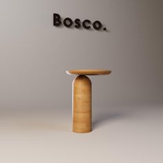 a wooden table sitting in front of a wall with the word bosco on it