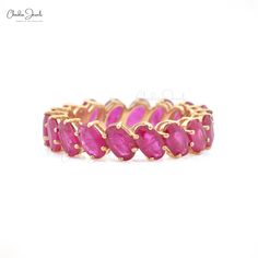 a gold ring with pink stones on it