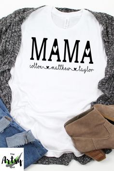 a white t - shirt with the word mum written in black on it, surrounded by jeans and shoes