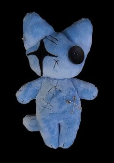 a small blue stuffed animal with black eyes