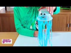 a young boy is playing with a plastic jellyfish toy that he made out of construction paper