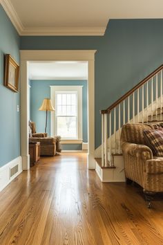 an empty living room with blue walls and wood flooring is seen in this image