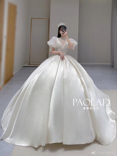 a woman in a white wedding dress is posing for the camera with her hand on her face