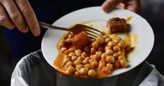 a person holding a plate with some food on it and a fork in the middle