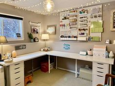 a home office with white desks and lots of lights on the ceiling above it