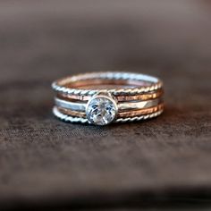 three stack rings on top of each other, with a diamond in the center and two smaller bands around them