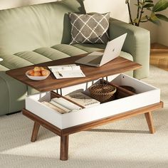 a living room with a couch, coffee table and laptop on top of the table