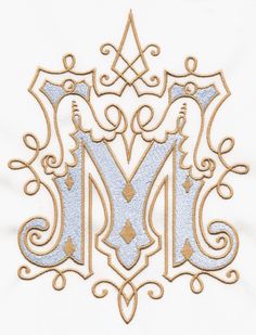 the letter m is made up of gold and silver thread with an intricate design on it