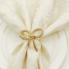 a white plate topped with a gold bow napkin