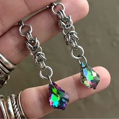 Handmade Maille & Purple Blue Green Pink Rainbow Iridescent Rainbow Austrian Crystal Dangly Earrings . Earrings Posts Are Stainless Steel . To Create The Maille Links I Use Stainless Steel Hoops As Well . It Is Nickel Free , Allergy Free , Hypoallergenic , No Itching , Do Not Change Color , Rust Or Turn Skin Green . Handmade By Me Any Questions Lmk ! Handcrafted / Boho / Bohemian / Boho Chic / Gypsie / Hippie / Festival / Goth / Gothic / Viking / Medieval / Victorian / Rock & Roll / Rocker / Roc Iridescent Pierced Drop Earrings, Hypoallergenic Rainbow Colored Metal Jewelry, Hypoallergenic Rainbow Metal Jewelry, Rainbow Metal Drop Earrings, Rainbow Dangle Metal Earrings, Iridescent Metal Jewelry For Jewelry Making, Surgical Steel Dangle Single Earring, Handmade Iridescent Metal Jewelry, Surgical Steel Single Dangle Earring