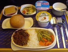 a tray with rice, meat and vegetables on it