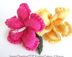 two knitted flowers sitting next to each other