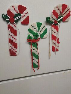 three candy canes are hanging on the wall next to each other, one is red and green