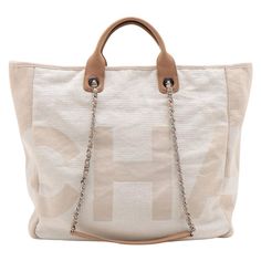 The Chanel Canvas Deauville Tote Bag in Light Beige is a chic and versatile accessory that effortlessly blends casual elegance with the iconic Chanel aesthetic. Crafted from durable canvas, the tote features oversized Chanel lettering all over the exterior, making a strong style statement. The light beige color adds an elegant touch to the bag's versatility. What sets the bag apart is the inclusion of both a chain strap and a leather strap, providing multiple carrying options. The spacious inter Chanel Aesthetic, Chanel Canvas, Beige Tote Bag, Vintage Chanel Bag, Strong Style, Beige Tote, Chanel Brand, Elegante Casual, Bag Light