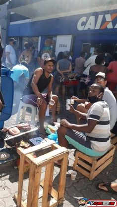 some people sitting on wooden benches near a building