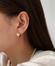 These dainty hoops feature a luminous pearl, perfect for adding a touch of elegance to any outfit. Available in both 18K gold and silver, these hoops are a must-have for any fashion-forward individual. Hoop size: 7.5 x 12mm