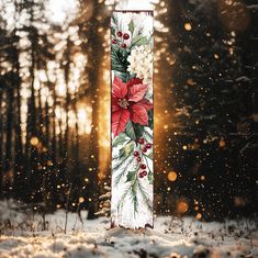 a christmas banner with poinsettis and holly on it in the middle of a snowy forest