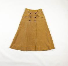 "-SO SO PRETTY!  -1950s heavy weight khaki corduroy circle skirt  -double breasted jacket button details  -waist measures 25 inches  -has small pockets at hips  -good vintage condition with the exception of some pressing of the corduroy here and there, there is also a small pen mark on the back right hip of the skirt  -tag says \"John Miller of Bryn Mawr\" MEASUREMENTS waist: 12.5 inches flat  hips: 20 inches flat  length: 30 inches" Vintage Brown Skirt With Buttons, Retro Brown Bottoms With Buttons, Vintage Brown Bottoms With Buttons, Vintage Winter Skirt With Buttons, Vintage Fall Skirt With Buttons, Vintage Skirt For Fall, Retro Brown Skirt With Button Closure, Retro Skirt With Button Closure For Fall, Vintage Fall Skirt With Pockets