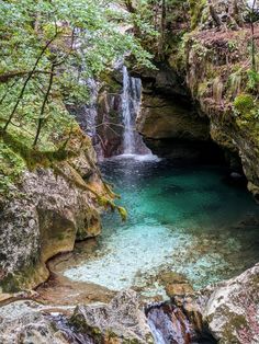 a small waterfall in the middle of a forest